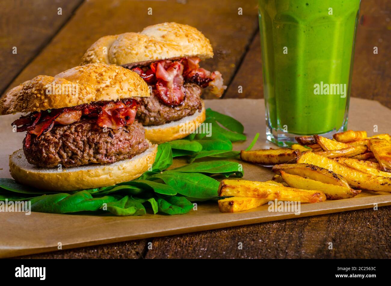 Bacon burger avec frites et herbes chili banana smoothie sur table en bois Banque D'Images Bacon burger avec frites et herbes chili banana smoothie sur table en bois Banque D'Images
