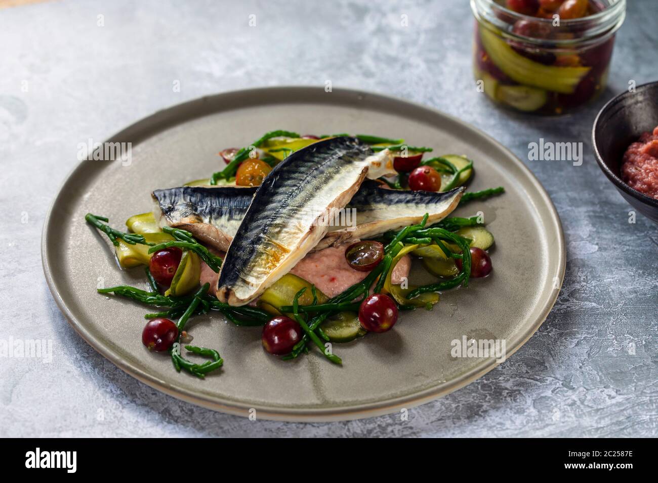 Maquereau grillé au ketchup aux groseilles à maquereau, concombre mariné, groseilles à maquereau entières et au saphir Banque D'Images