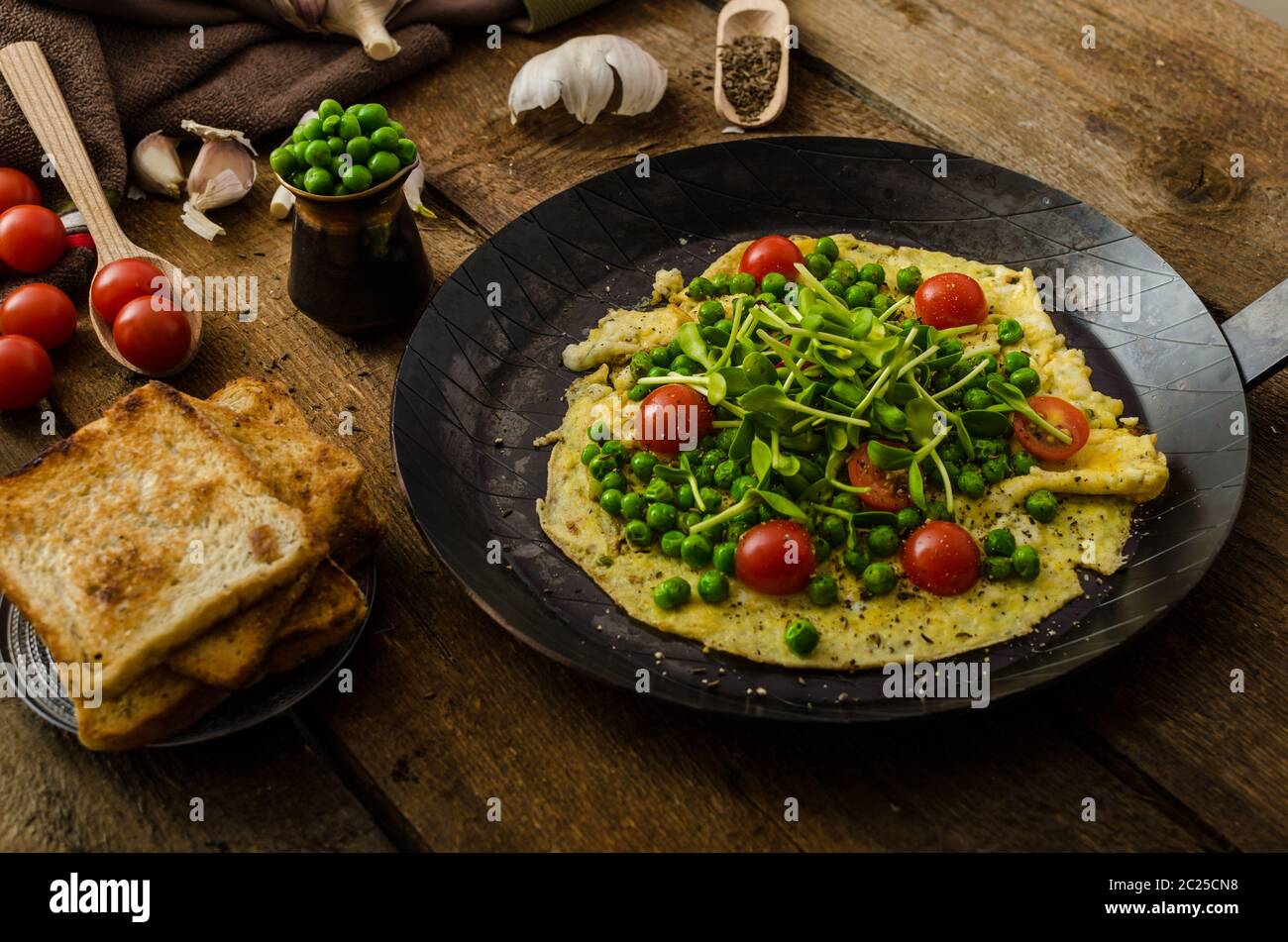 Omelette aux légumes sains - pois et tournesol microgreens, tomates cerises rôties Banque D'Images