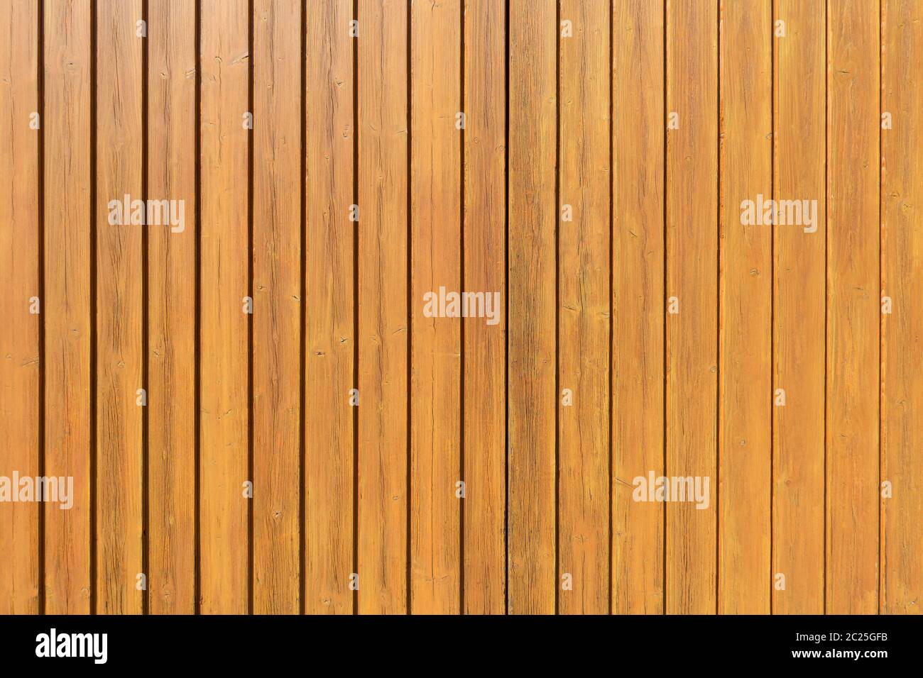 Détail d'un mur en bois de couleur miel en panneaux verticaux Banque D'Images