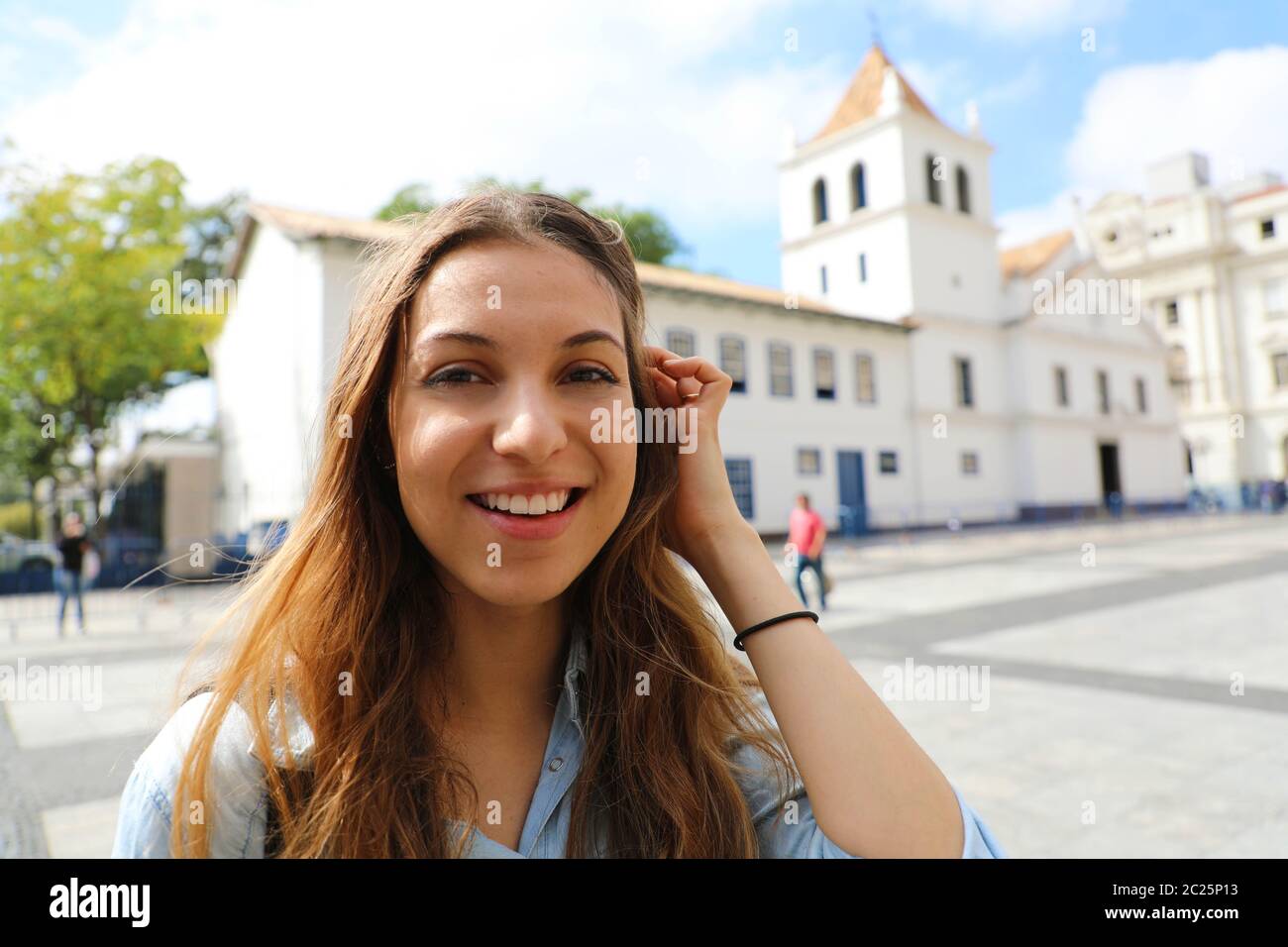 Happy smiling young woman in Sao Paulo centre ville avec Patio do Colegio vue sur l'arrière-plan, Sao Paulo, Brésil Banque D'Images