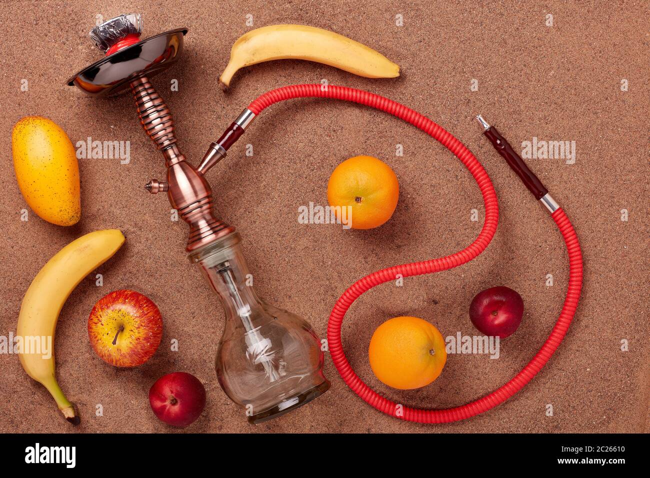 Nargua turc (shisha) et fruit sur fond de sable. Banque D'Images