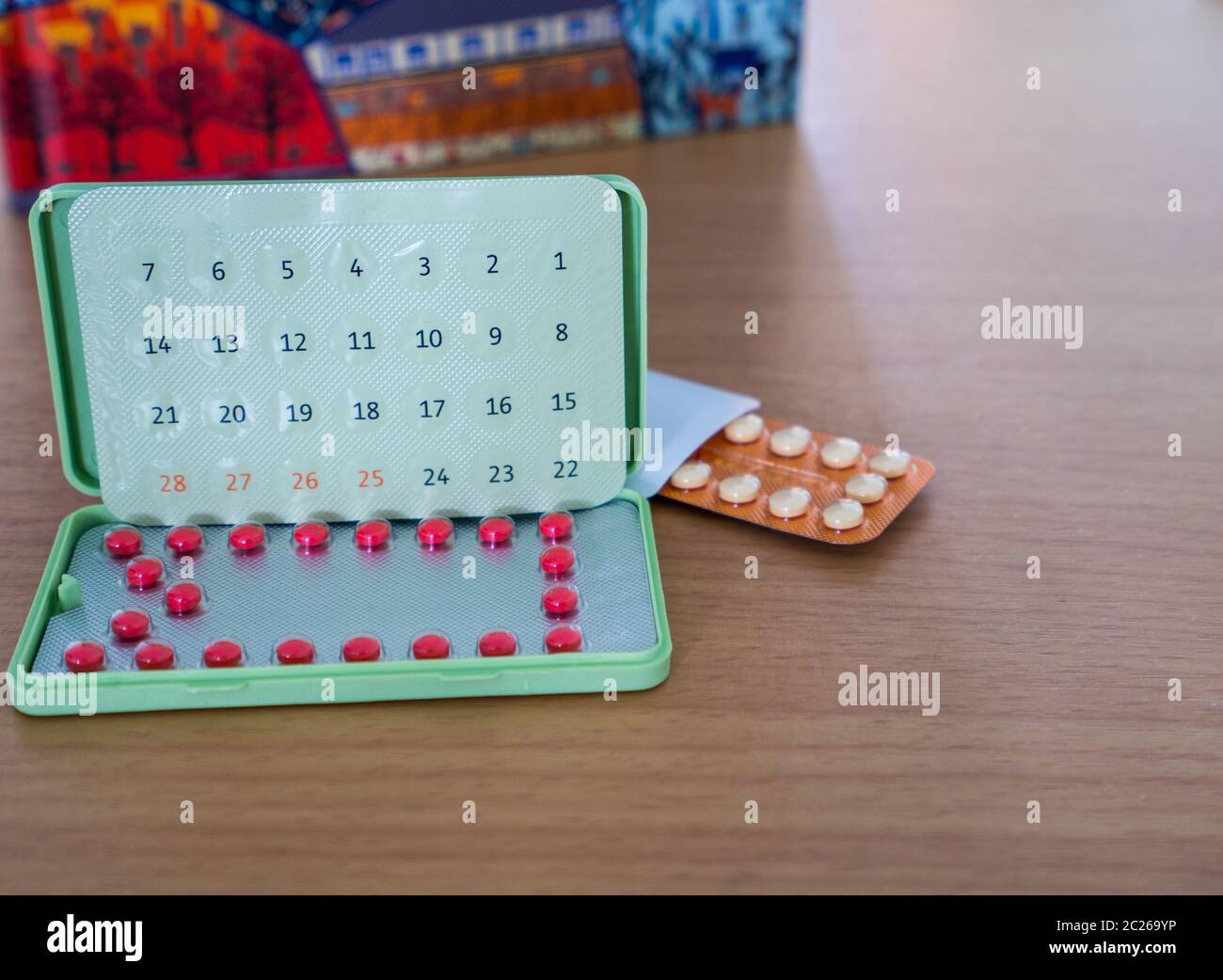 Pilules contraceptives avec emballage moderne sur la table de travail en bois brun à côté du carnet. Pilules contraceptives en blister. Planification familiale. Hormones Banque D'Images