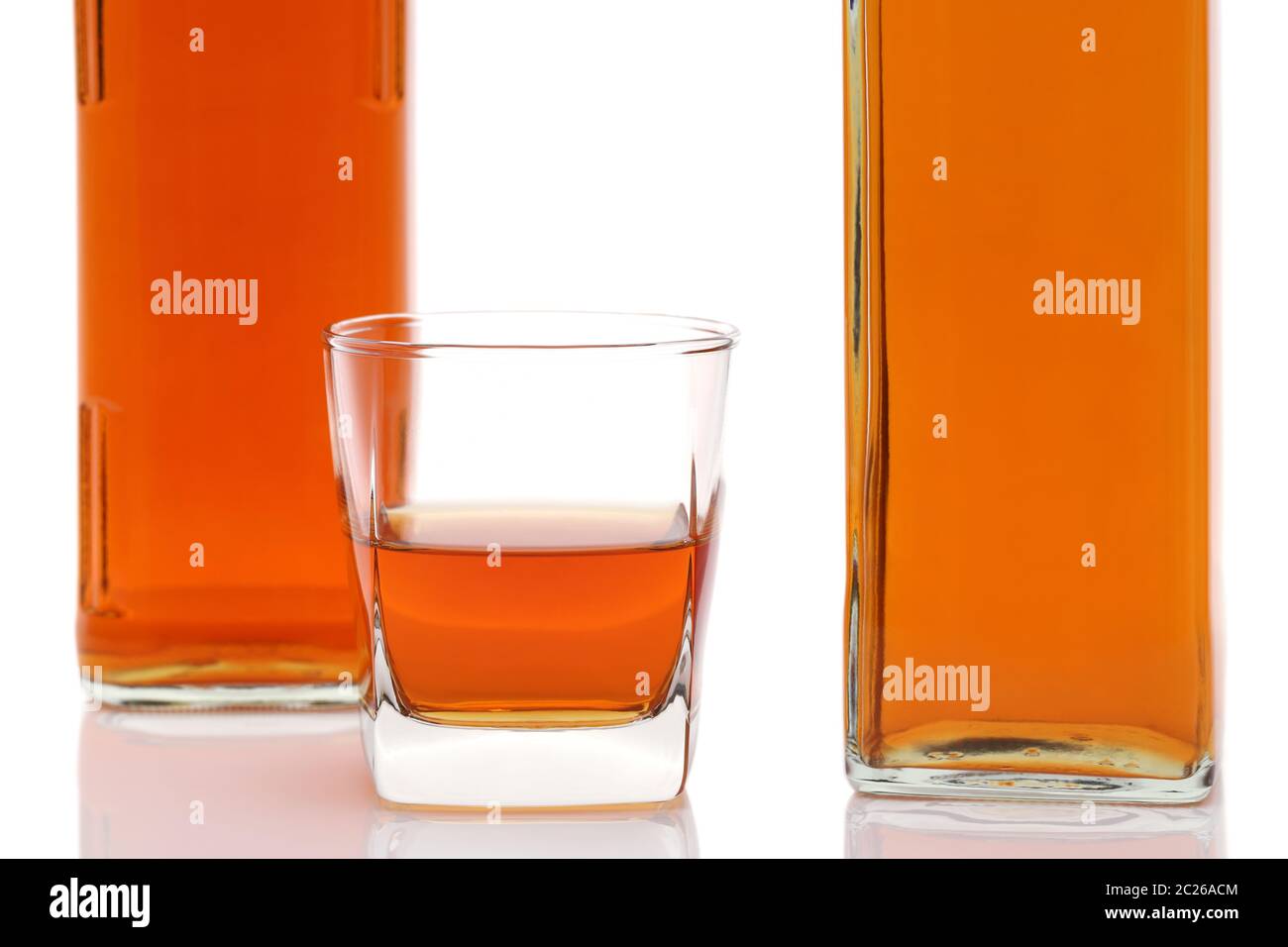Tasse en verre et bouteille de whiskey sur fond blanc Banque D'Images