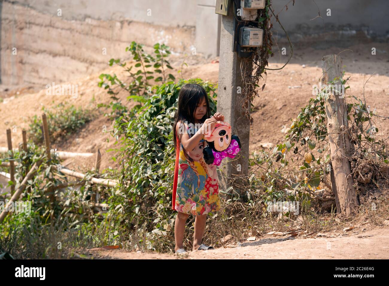 Une jeune fille de Khmu, indigène et ethnique, qui gonfle un ballon dans son village de la province de Luang Namtha, dans le nord du Laos. Banque D'Images