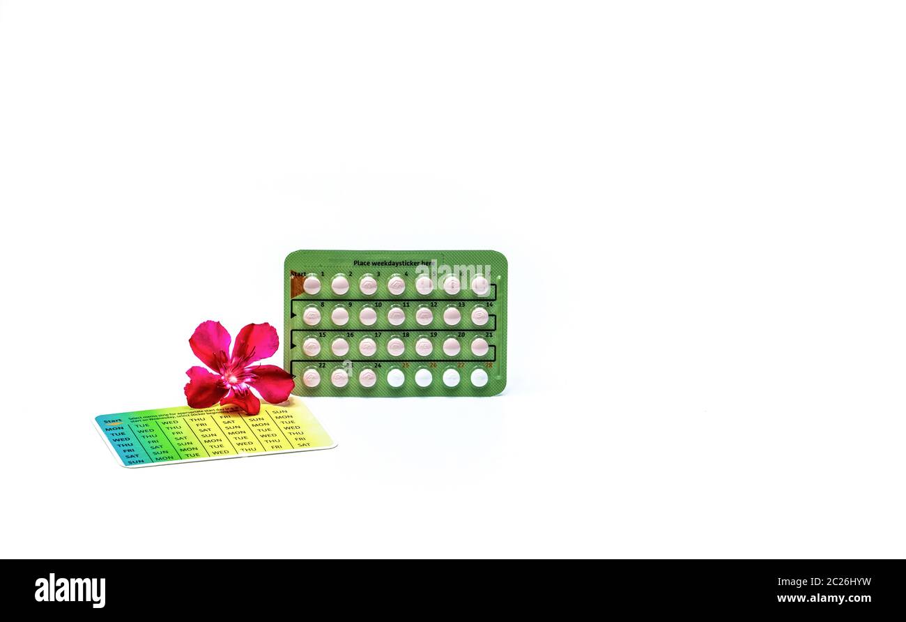 Pilules contraceptives ou pilules contraceptives avec fleur rose isolée sur fond blanc. Hormone pour la contraception. Planification familiale. Comprimés d'hormones Banque D'Images