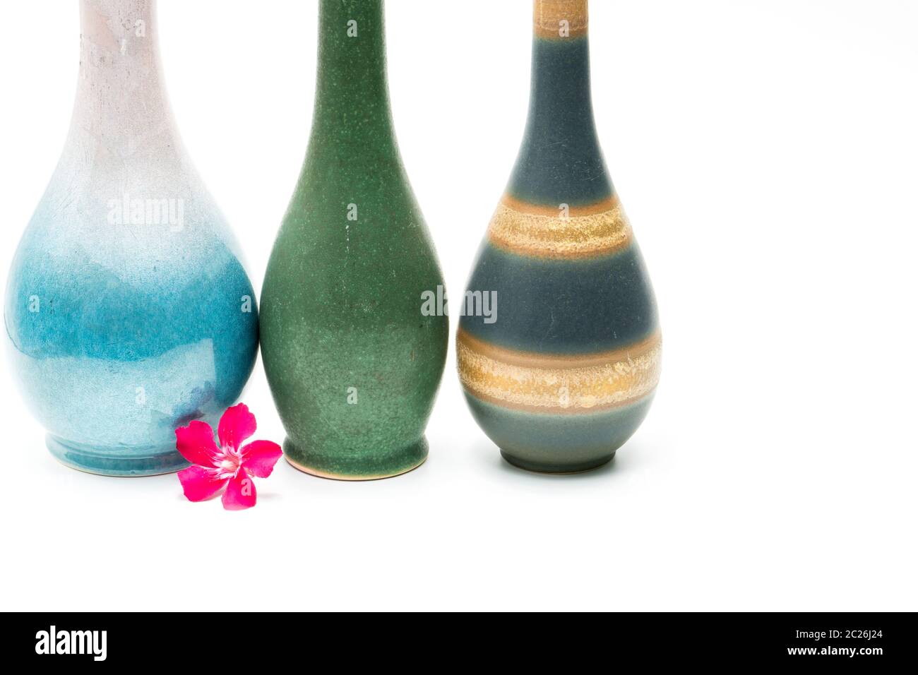 Vases en poterie moderne avec de beaux motifs, fleurs roses en face de vases isolé sur fond blanc Banque D'Images