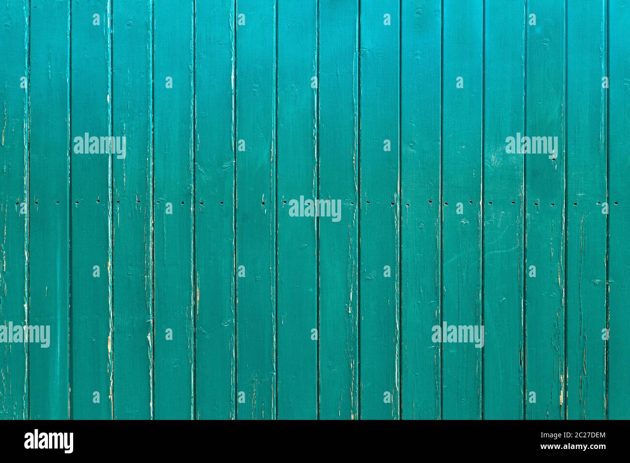 Légèrement abîmé, mur en bois turquoise de planches verticales avec une rangée de trous de vis au milieu Banque D'Images