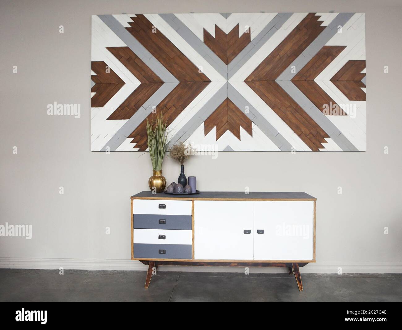 Partie de l'intérieur de la pièce avec commodes en bois, vases vintage et bougies contre les murs clairs Banque D'Images