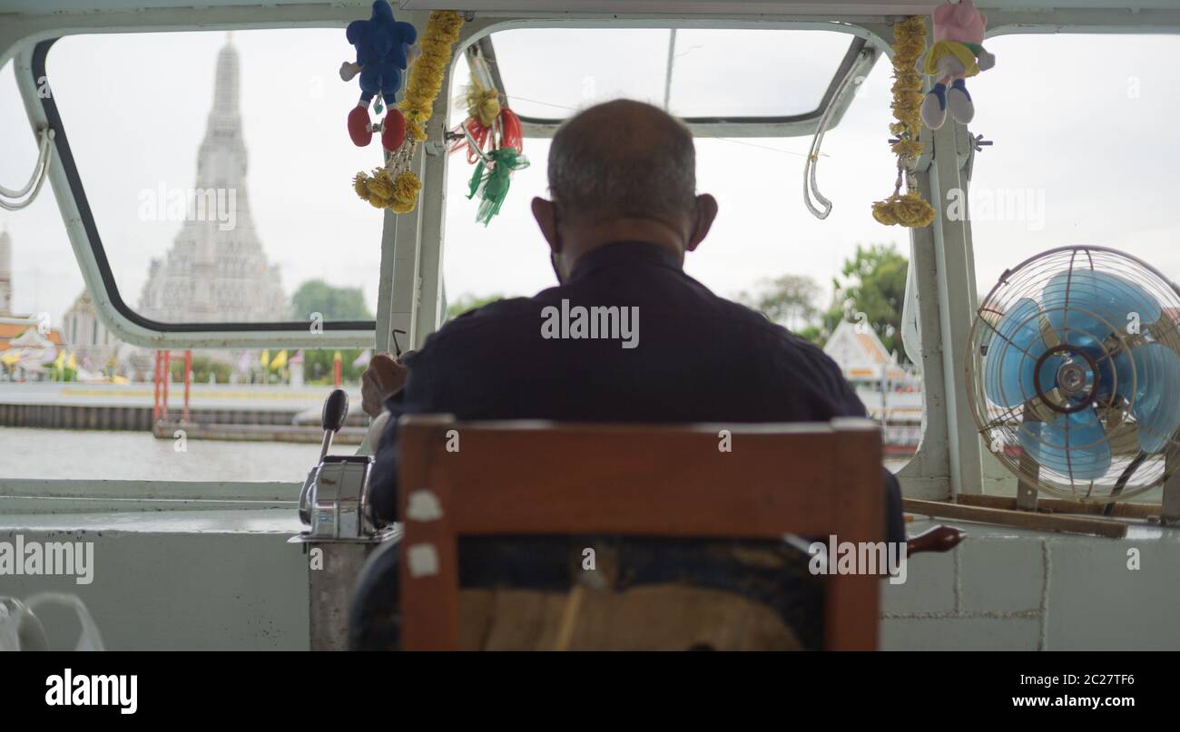 Un chauffeur de bateau qui assure le service de ferry entre le port du Grand Palais royal et la région de Wat Arun, Bangkok Thaïlande Banque D'Images