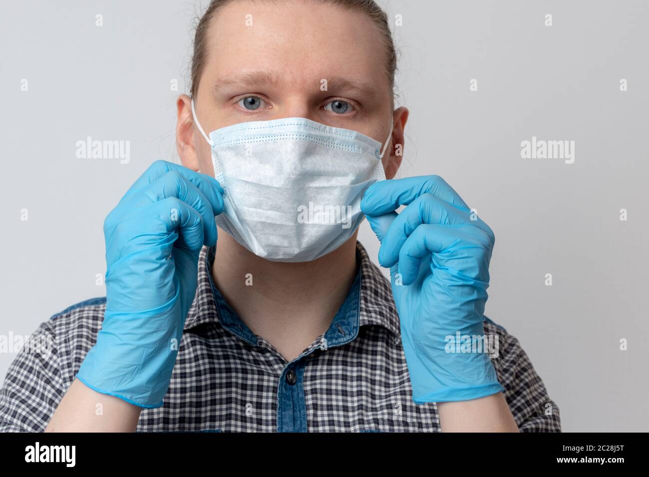 Guy met sur masque respiratoire. Un homme attrayant met un masque et regarde l'appareil photo. Rhume, grippe, virus, amygdalite, maladie respiratoire aiguë, quaranti Banque D'Images