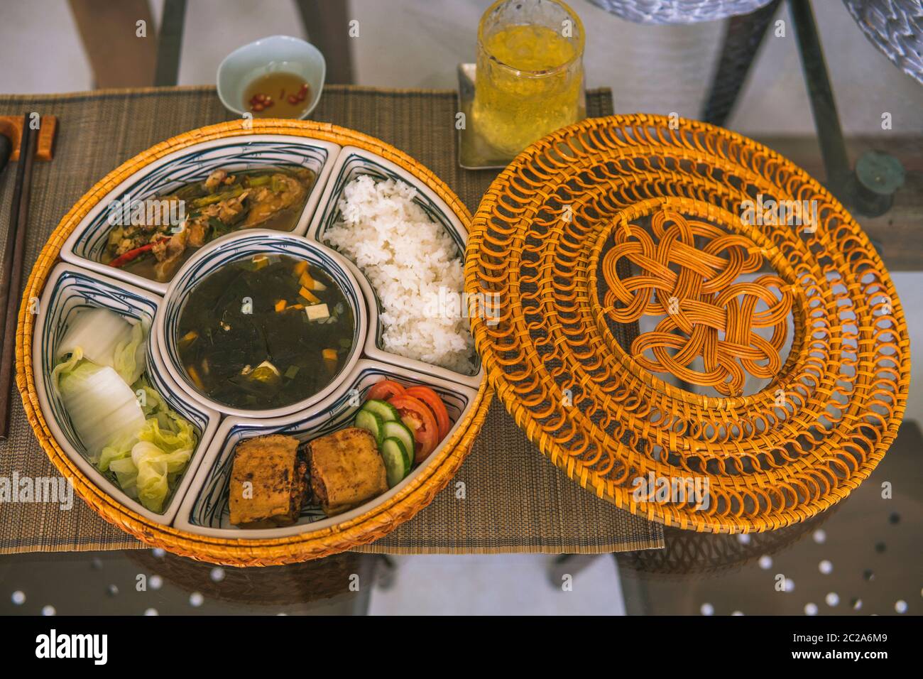 Bol à riz en rotin, à l'intérieur, déjeuner traditionnel vietnamien, riz, soupe, aliments salés. La scène est frugal et paisible. Concept de nourriture et de boissons. Banque D'Images