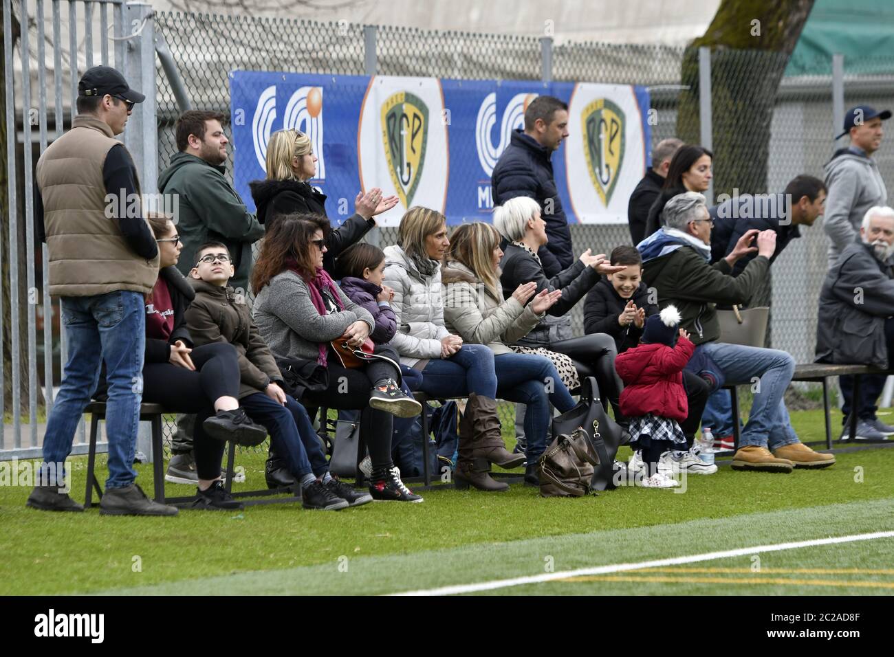 Parents regardant et soutenant le match de football des enfants, à Milan. Banque D'Images