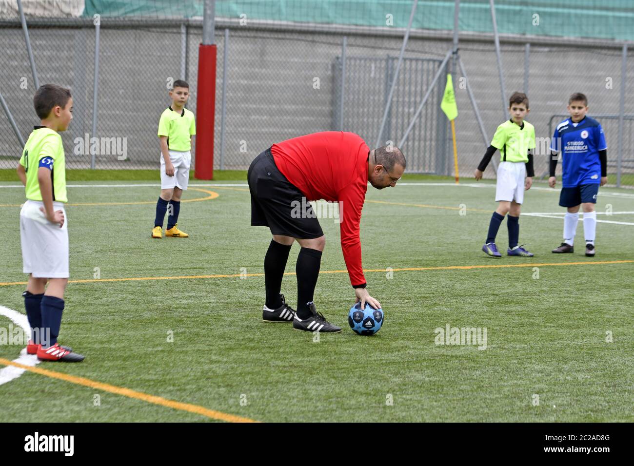 Arbitre de football, portant un uniforme rouge lors d'un match de football pour enfants, à Milan. Banque D'Images