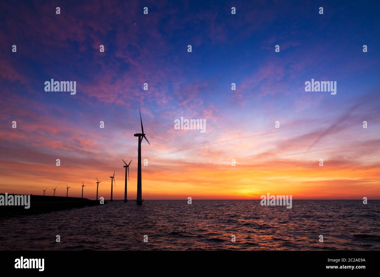 Magnifique vue sur le lac Markermeer avec de multiples éoliennes modernes pour une énergie verte durable aux pays-Bas au coucher du soleil Banque D'Images