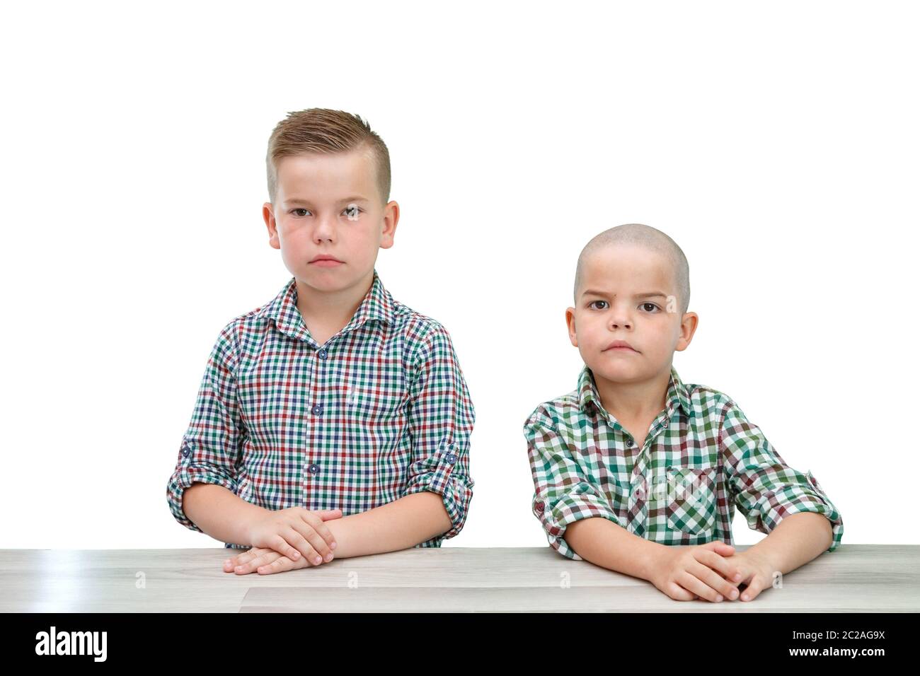 Deux garçons de race blanche ,frères en chemises à carreaux posant sur un léger fond isolé. à dans l'appareil photo Banque D'Images