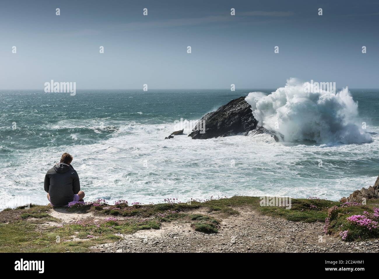 Un touriste appréciant la vue spectaculaire de Pentire point East sur la côte de Newquay dans les Cornouailles. Banque D'Images
