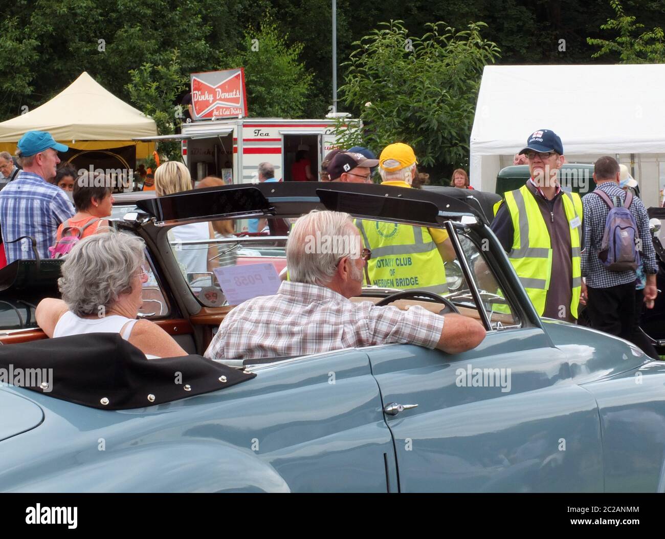 un couple plus âgé qui passe devant des volontaires du club rotary dans le parc public du pont hebden, le week-end annuel d'époque Banque D'Images