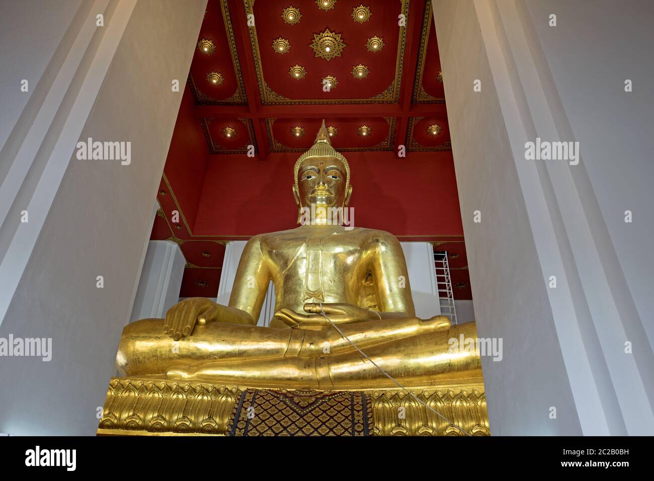 Assise de la statue de Bouddha doré, à l'intérieur d'un temple de l'ancienne capitale thaïlandaise, à Ayutthaya. Banque D'Images