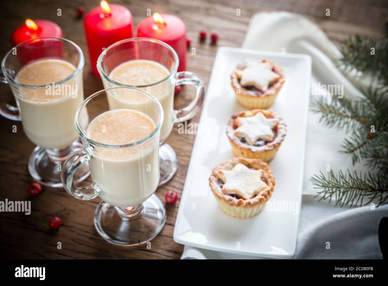 Des verres de lait de poule avec des tartes à la viande Banque D'Images