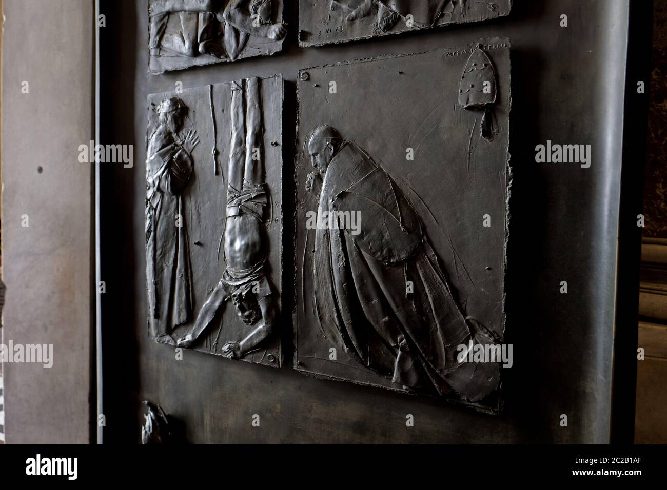 La crucifixion Saint-Pierre est sculptée sur une porte d'entrée en marbre de la cathédrale Saint-Pierre, à Rome. Banque D'Images