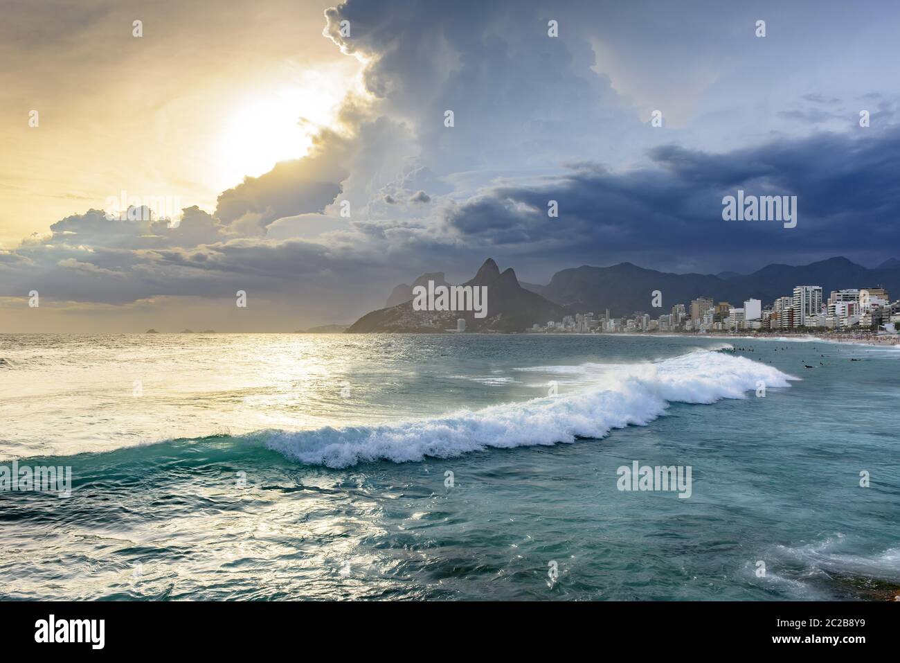 Coucher de soleil nuageux avec surfeurs sur la plage d'Ipanema Banque D'Images