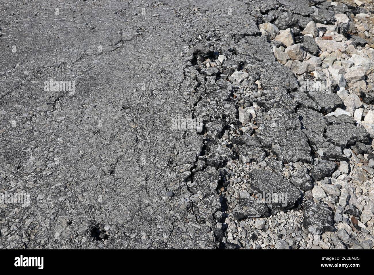 Ancienne surface de route cassée. Une vieille route brisée Banque D'Images