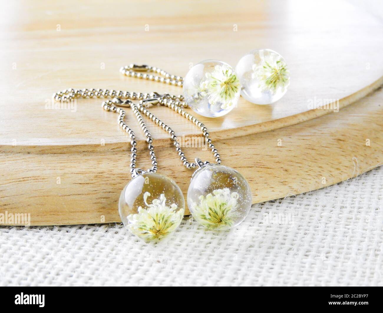 Les fleurs séchées en résine crystal clear, pendentif pendentif avec un vrai fleurs. Banque D'Images