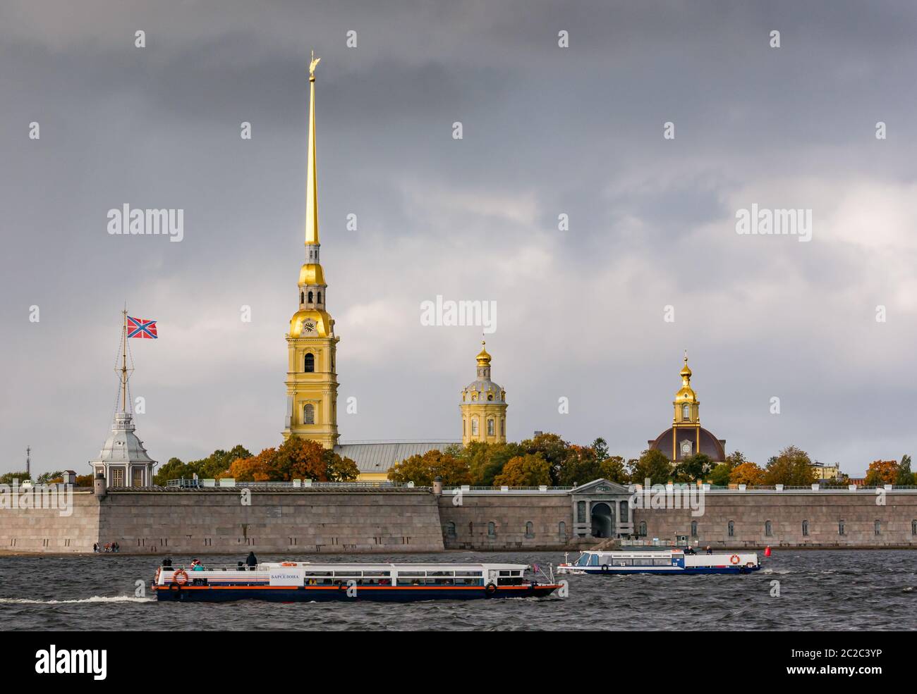 Cathédrale Pierre et Paul, forteresse Pierre et Paul sur la Neva avec bateaux touristiques et ciel orageux, Saint-Pétersbourg, Russie Banque D'Images