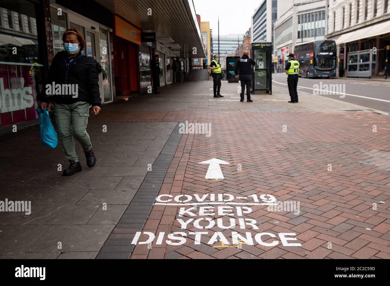 Un acheteur marche à côté des instructions de distance sociale à Birmingham, alors que d'autres restrictions de verrouillage du coronavirus sont levées en Angleterre. Banque D'Images