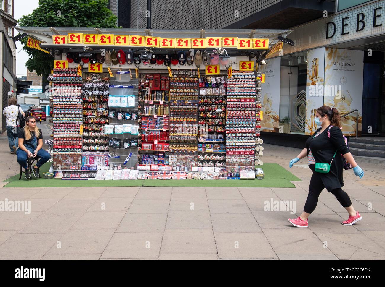 Un cabas portant un masque facial de protection passe devant un stand souvenir à Oxford Street, Londres, alors que d'autres restrictions de verrouillage du coronavirus sont levées en Angleterre. Banque D'Images