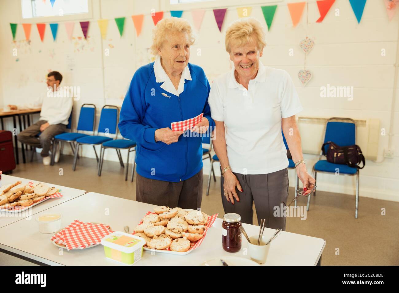 En vue de face tourné de deux cadres supérieurs de la vente d'amis lors d'une vente de pâtisseries des scones. Banque D'Images