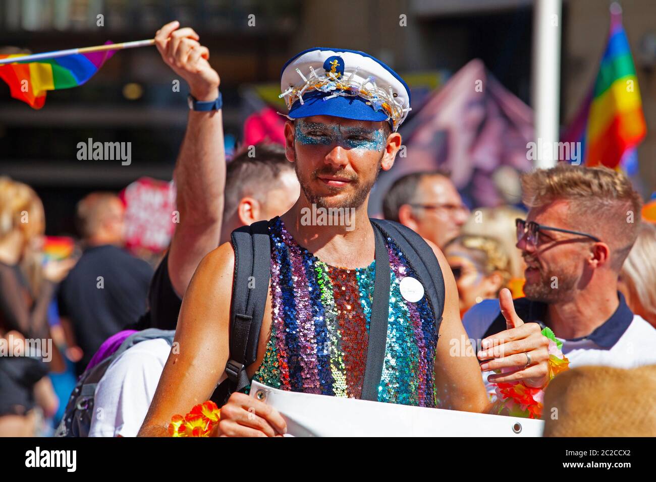 Homme souriant, flamboyant vêtu d'une casquette de marin lors de la marche gay Pride 2019 à Cardiff Banque D'Images