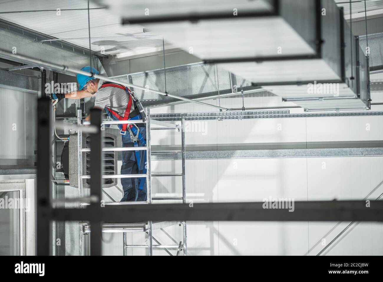 Thème climatisation. Installation d'une unité de chauffage commerciale dans  un entrepôt par un technicien de chauffage et de refroidissement de race  blanche Photo Stock - Alamy