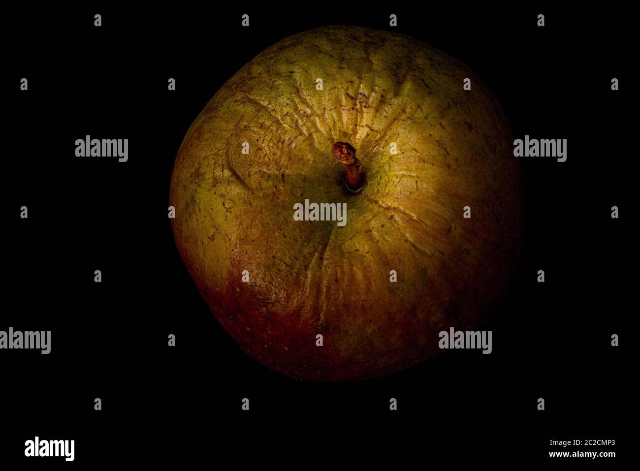 Une vieille pomme froissée de l'automne dernier, sur fond noir, vue du dessus. Concept du vieillissement, et les changements physiques qui viennent avec lui Banque D'Images