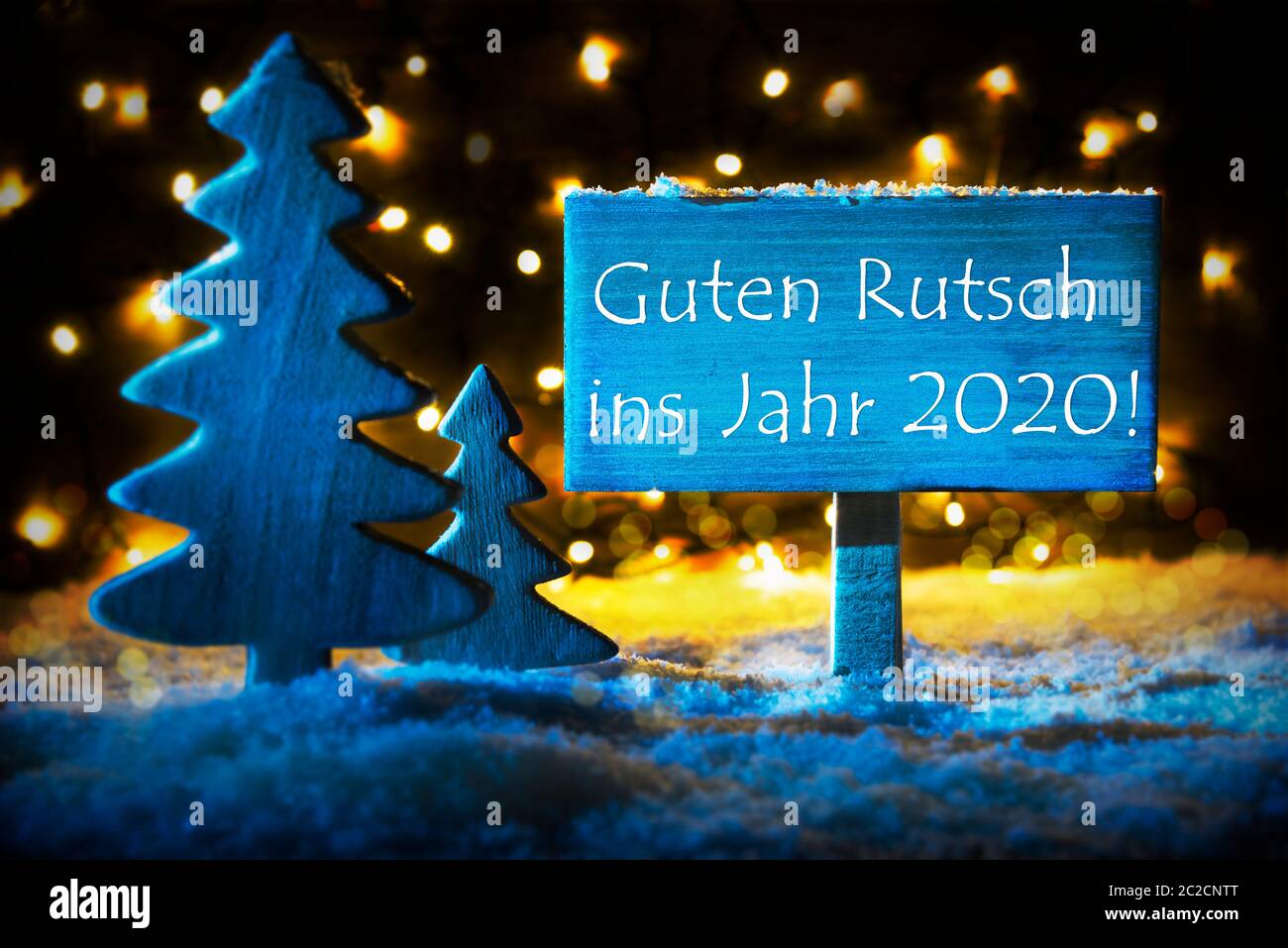 Panneau avec texte Allemand Guten Rutsch 2020 signifie Bonne année 2019. Blue Christmas Tree avec de la neige et de la magie des feux lumineux en contexte. Carte pour Seaso Banque D'Images