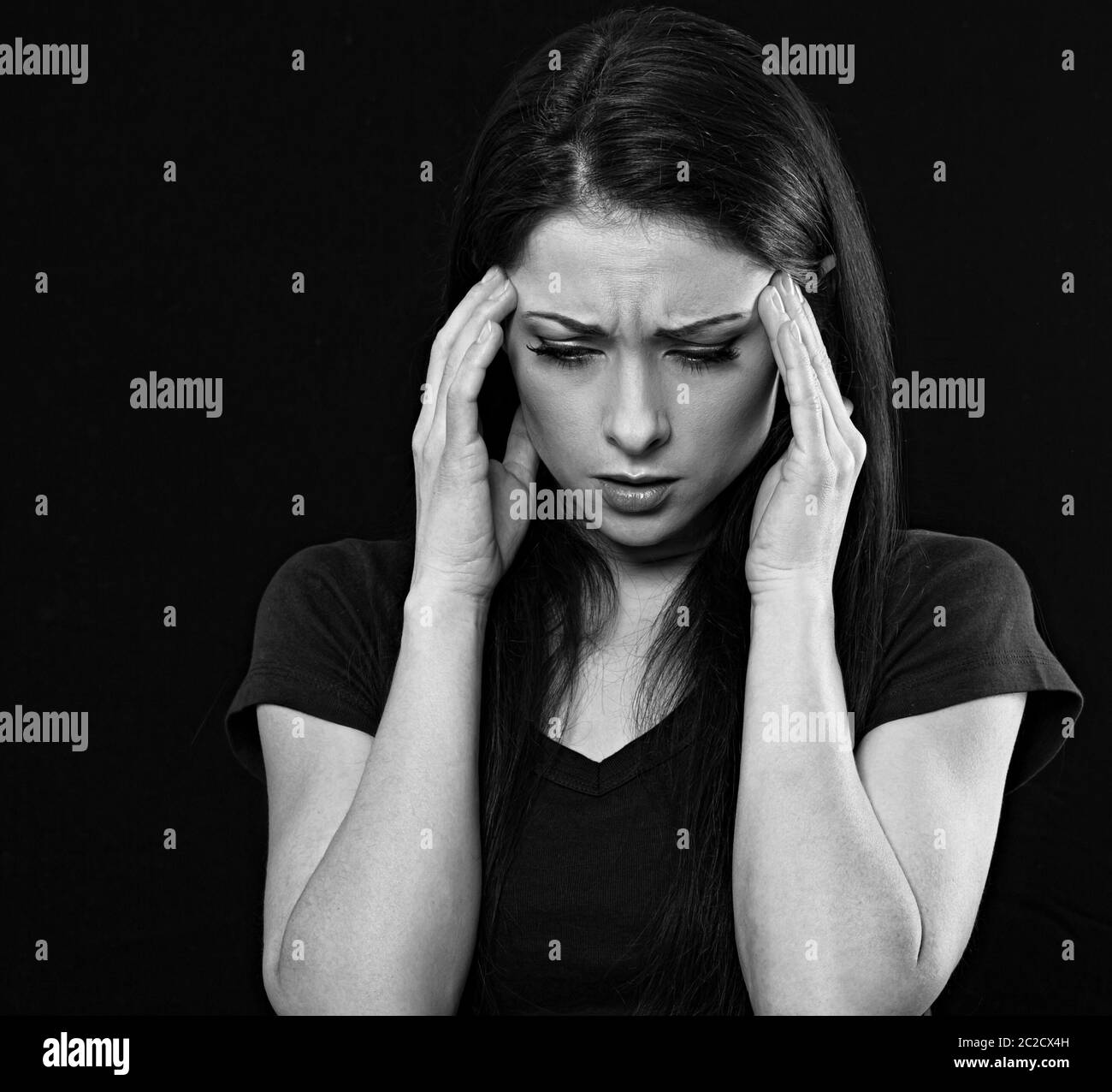 Très concentrée sérieuse femme d'affaires tenant la tête les mains et de trouver la solution sur la situation de problème. Virus Corona. Portrait de studio. Noir a Banque D'Images