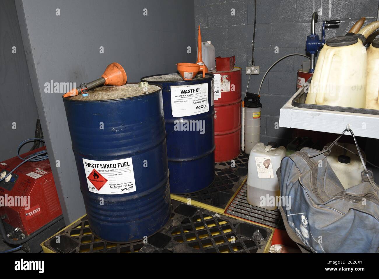 Station d'élimination des déchets de carburant dans un atelier d'ingénierie au Royaume-Uni. Scène de travail réelle avec des barils, des équipements et de la saleté. Banque D'Images