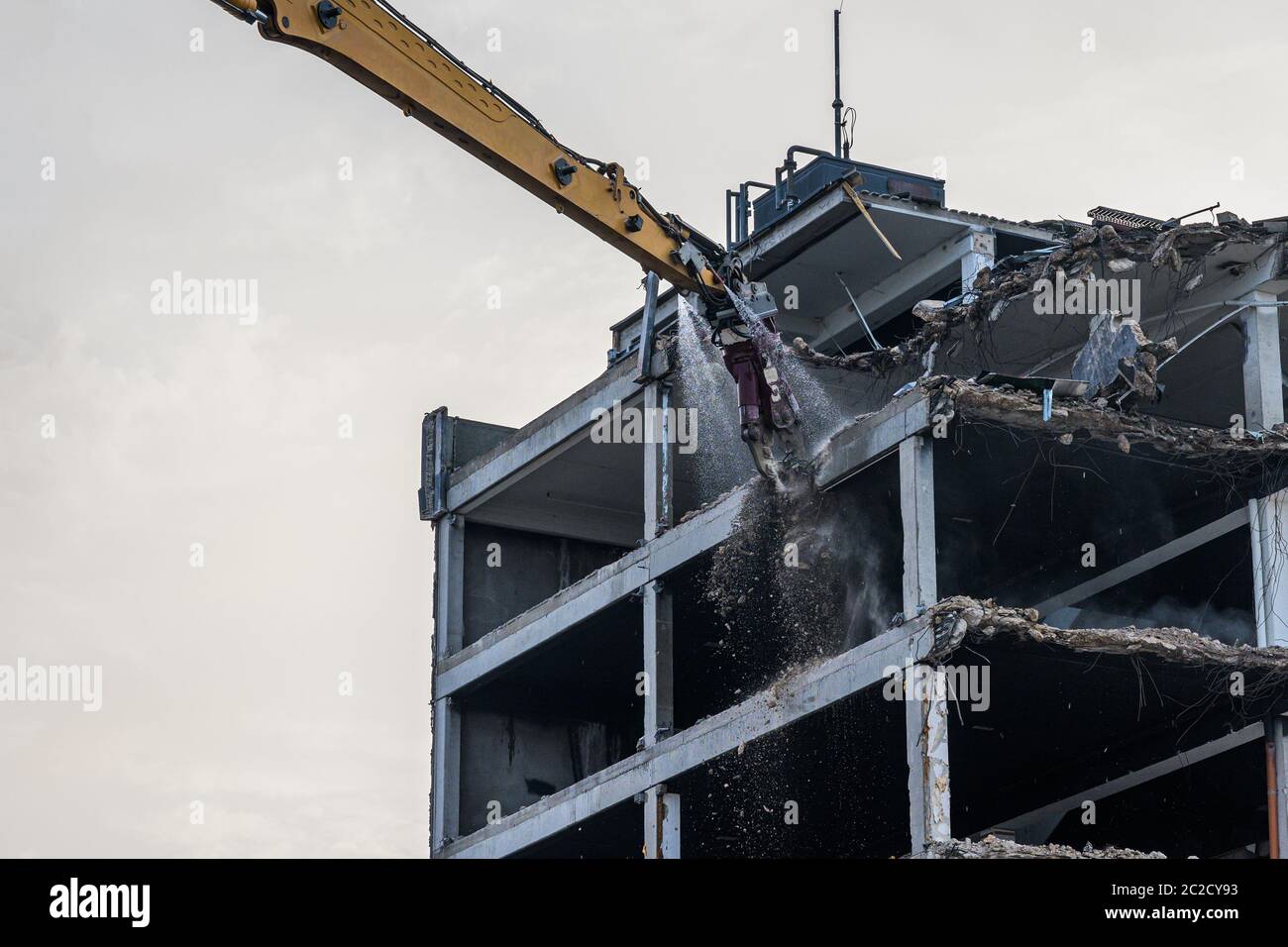 Destruction de bâtiments site de démolition Pelle hydraulique avec machine de concasseur hydraulique ruine maison. Banque D'Images