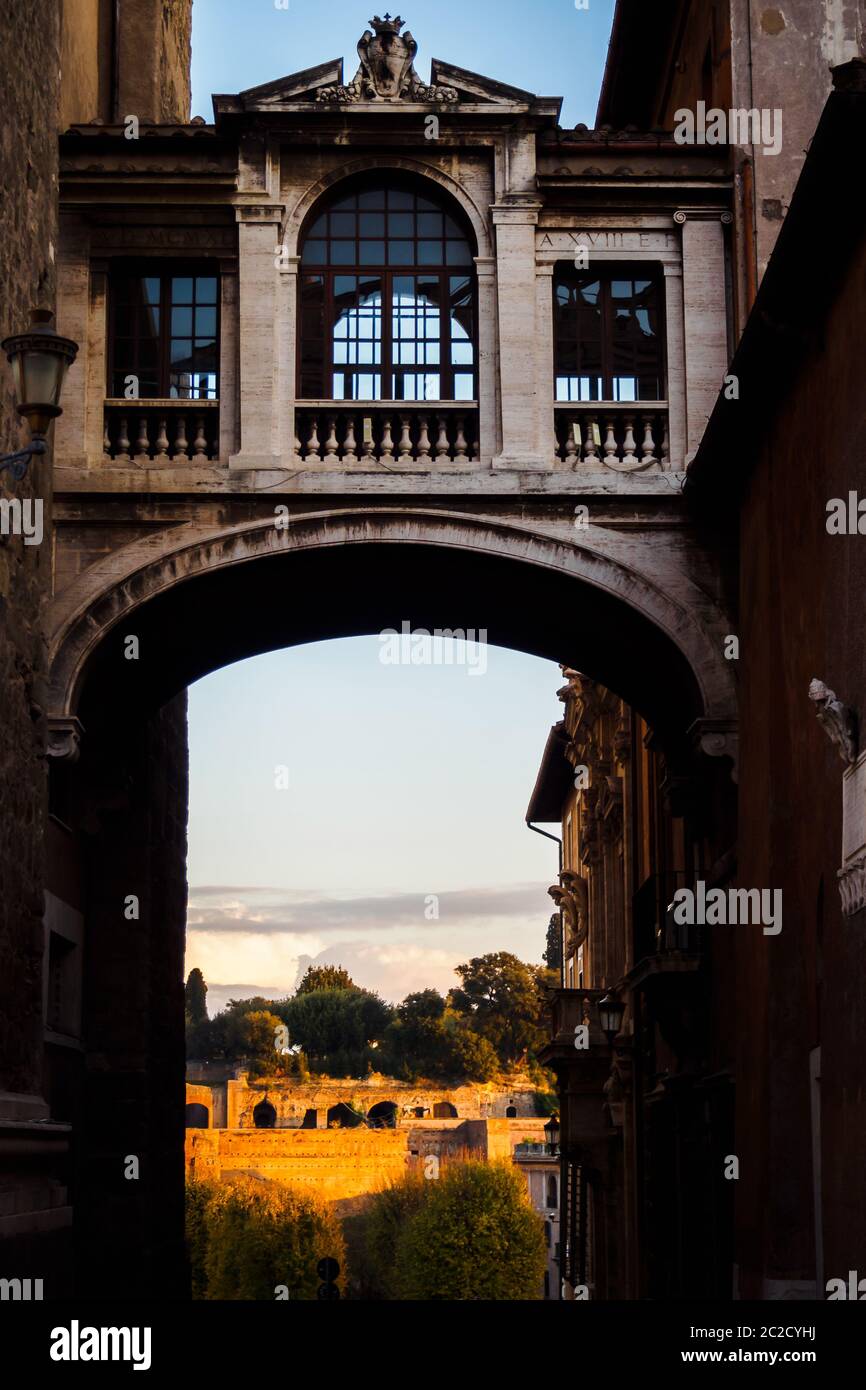 Passage aux ruines sous une ancienne passerelle entre deux bâtiments typiques de Rome, Italie Banque D'Images