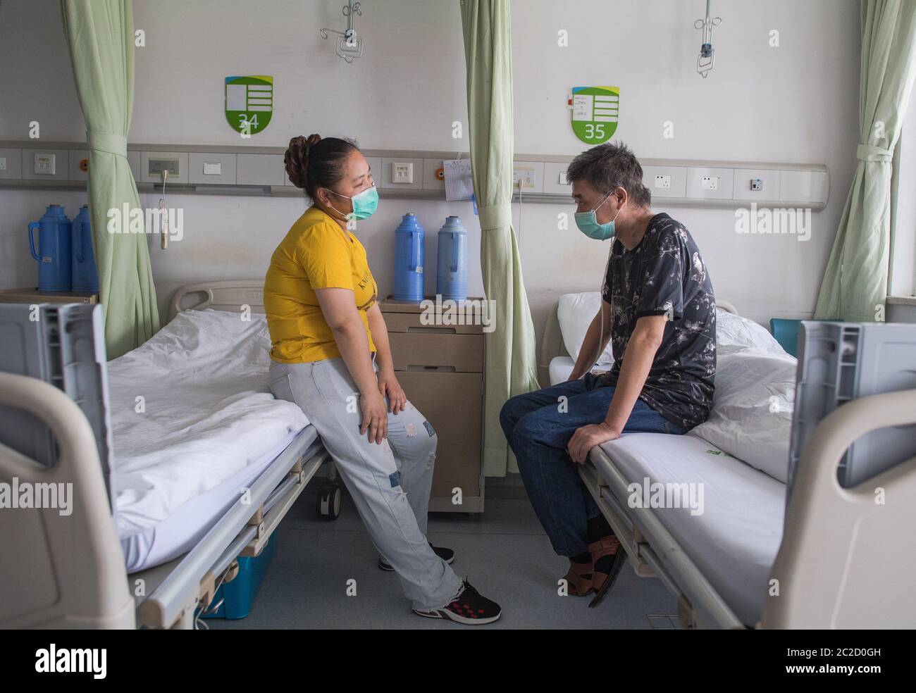 (200617) -- WUHAN, 17 juin 2020 (Xinhua) -- Hu Dingjiang attend d'être libéré de l'hôpital avec sa femme dans un quartier de l'hôpital pulmonaire de Wuhan à Wuhan, dans la province de Hubei, en Chine centrale, le 17 juin 2020. Hu Dingjiang, 40 ans, un patient COVID-19 retrouvé, a quitté l'hôpital pulmonaire de Wuhan mercredi après avoir reçu un traitement médical et une formation de réadaptation pendant plus de 100 jours. Il a reçu un diagnostic de maladie début février et a été hospitalisé dans le service de soins intensifs comme l'un des 81 cas graves de COVID-19 à l'hôpital. Les fonctions de ses poumons ont récupéré le 5 avril avec 4 Banque D'Images