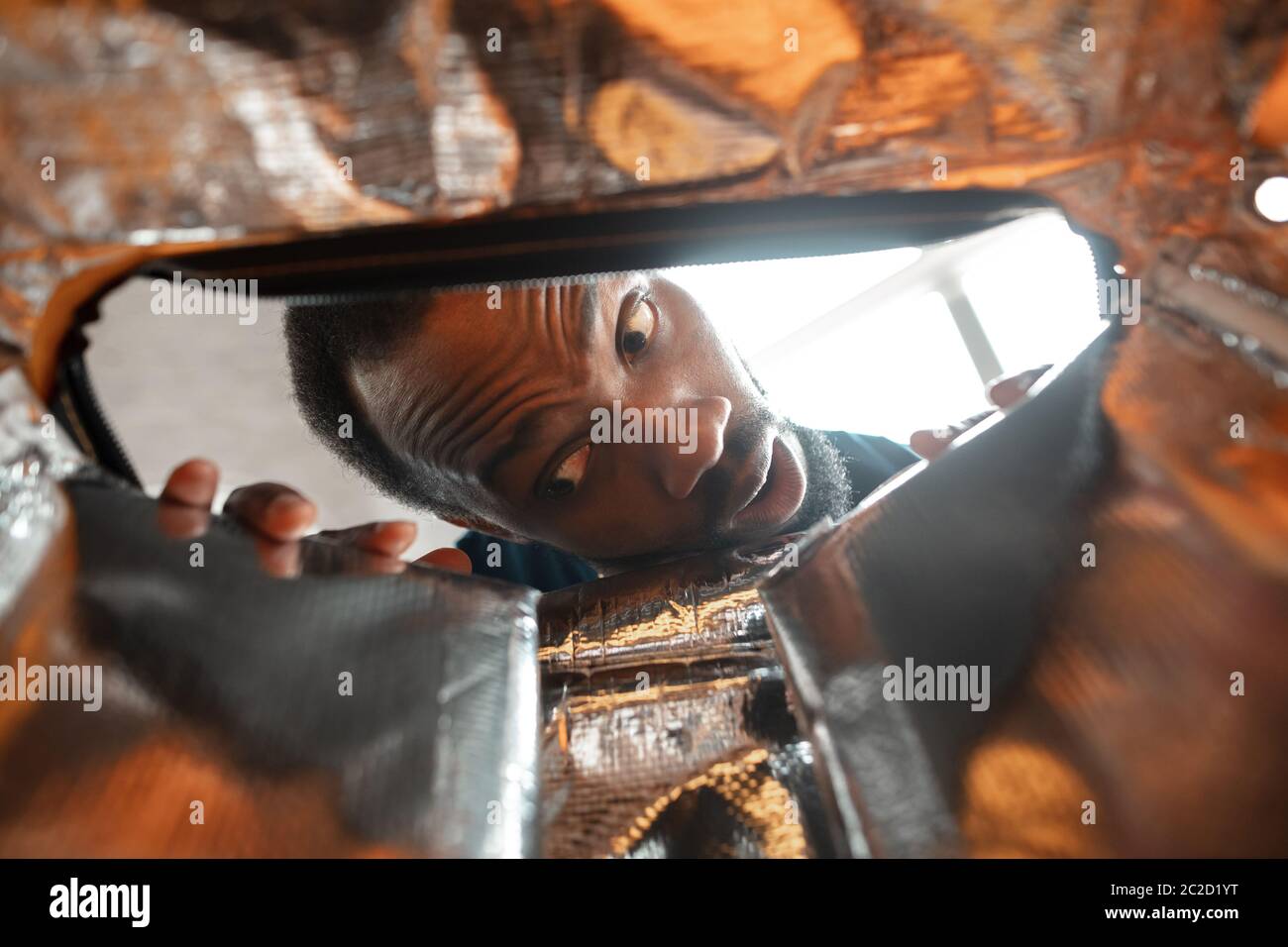 Dans une ancienne boîte postale. Homme afro-américain à la recherche d'un emploi dans des endroits inhabituels à sa maison. Une façon folle et amusante de trouver une carrière et de se lever. Concept de crise, chômage, finances, affaires. Banque D'Images