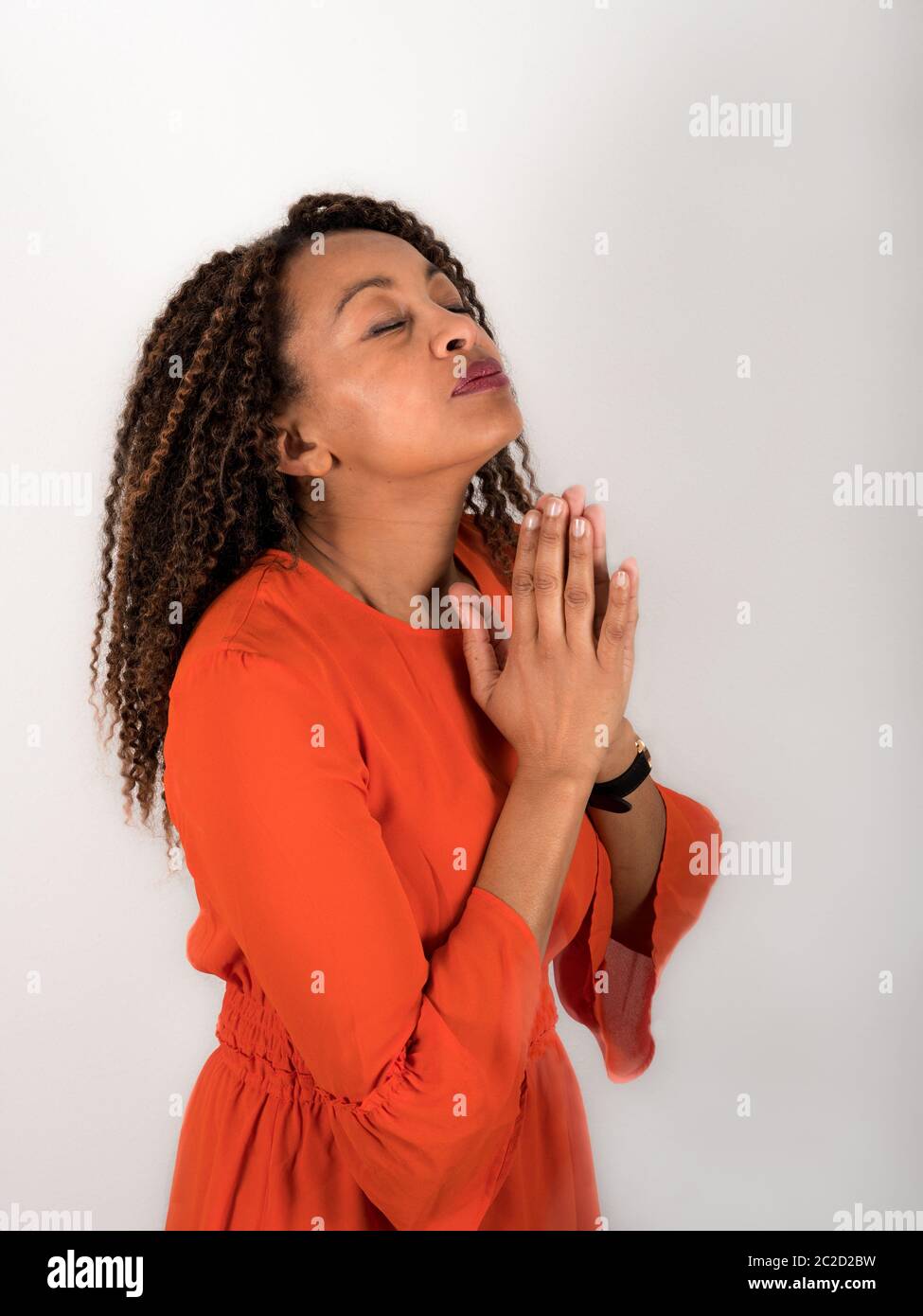 Portrait vertical de la femme afro-américaine qui priait les yeux fermés Banque D'Images