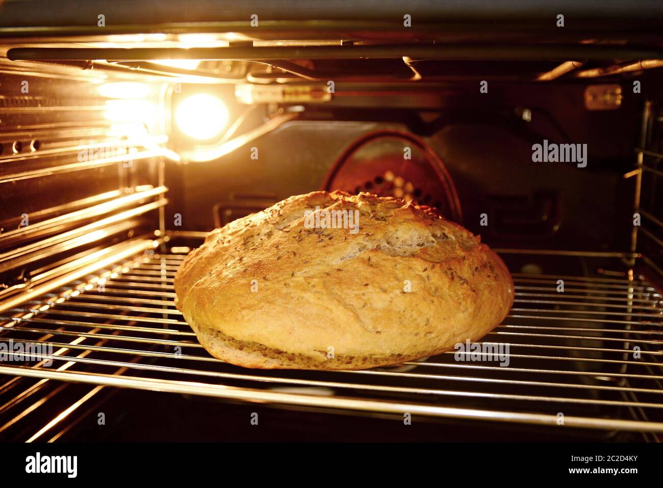 Cuisson de pain maison au four. Regarder au four pendant la cuisson du pain sur grille métallique. Banque D'Images