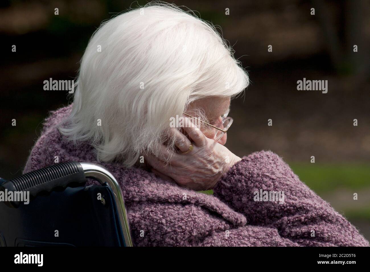 une femme âgée malheureuse a à moitié dormi en fauteuil roulant Banque D'Images