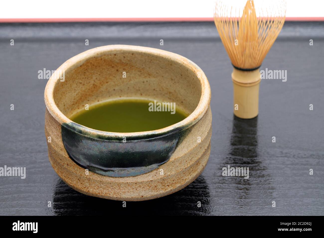 Thé vert japonais Matcha dans un bol en céramique avec plateau fouetter Banque D'Images
