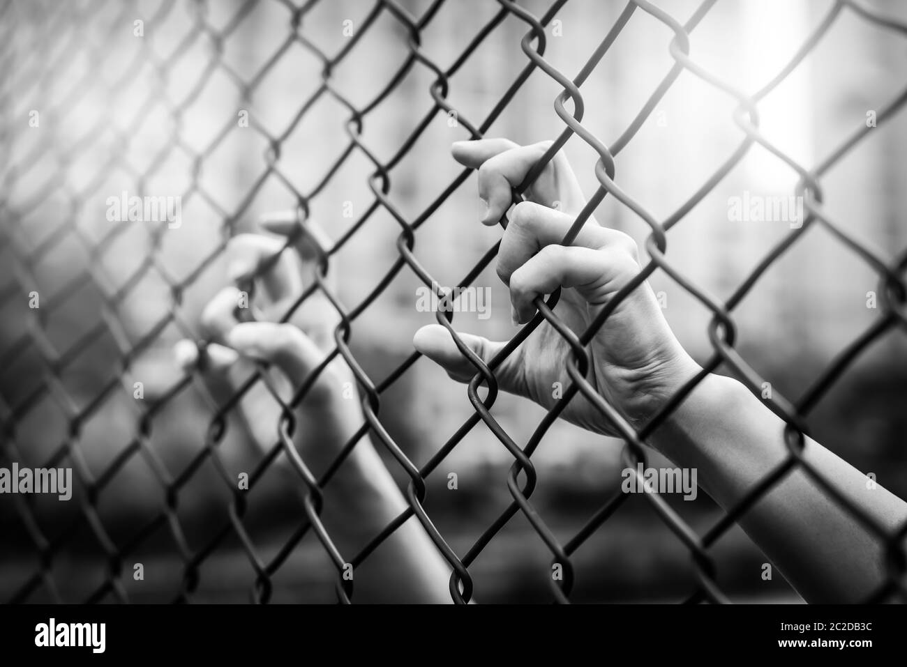 Déprimée, les problèmes et les vies comptent. Filtre noir et blanc, les femmes se font une clôture à maillons de chaîne. Banque D'Images