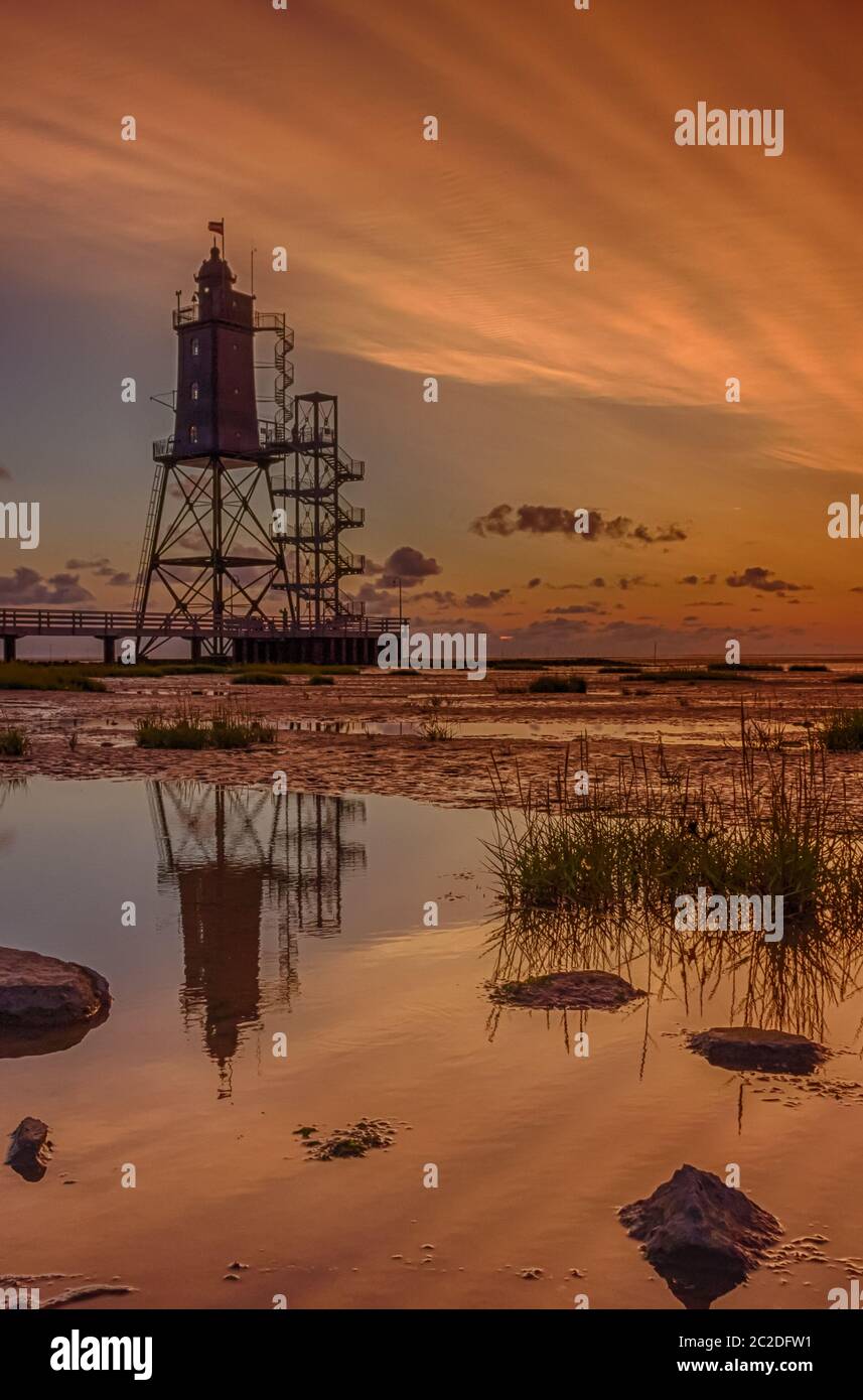 Phare de la mer Obereversand au coucher du soleil avec la réflexion Banque D'Images