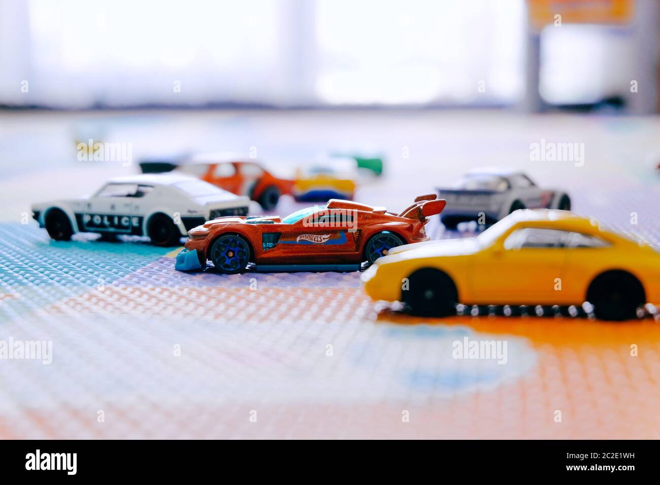 Petits jouets colorés Hot Wheels voitures par Mattel dans la salle des enfants tapis de jeu Banque D'Images