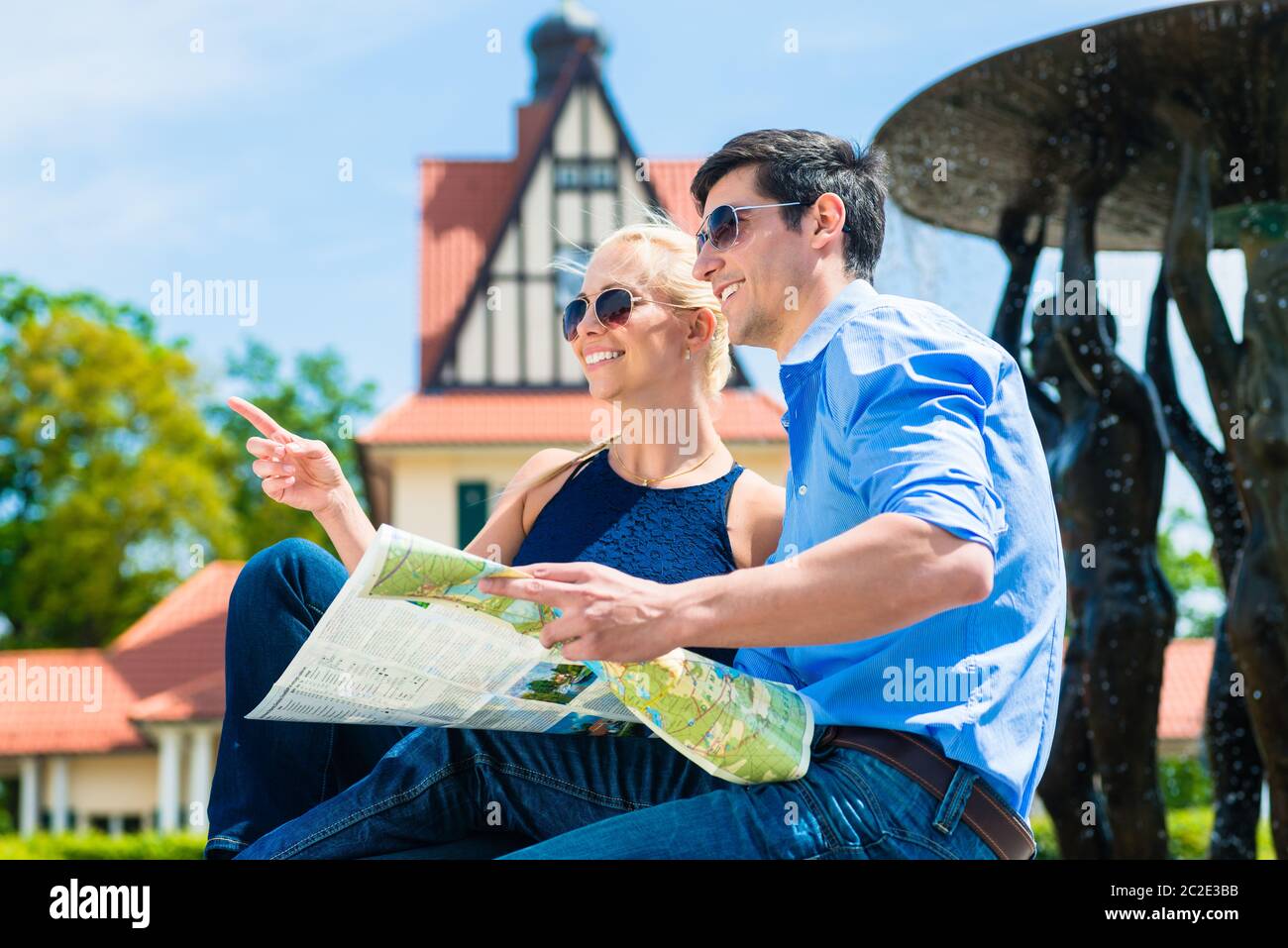 Portrait d'un jeune couple souriant explorant l'endroit tenant la carte entre les mains Banque D'Images